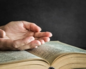 hands in prayer over bible